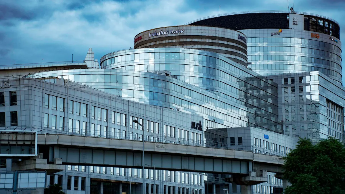 Moderne Bankgebäude mit gebogener Glasfassade vor blauem Himmel mit Wolken