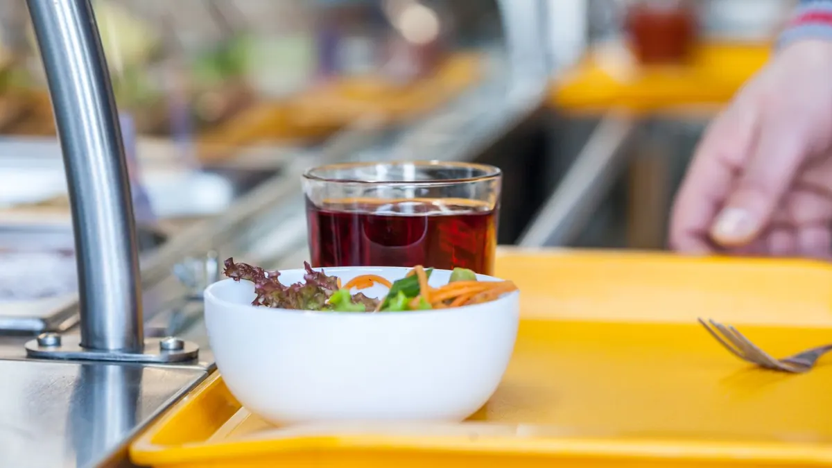 Tablett mit Salat und einem Getränk in einer Kantine