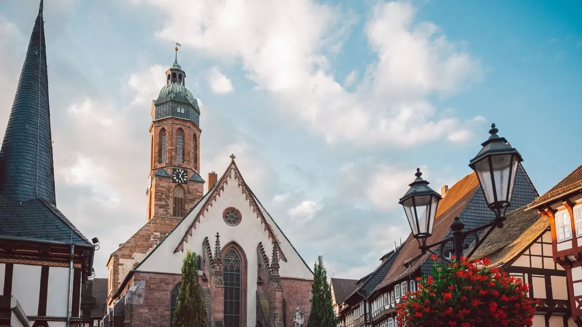Kirchturm mit Uhr und Fachwerkhäuser in einer deutschen Altstadt