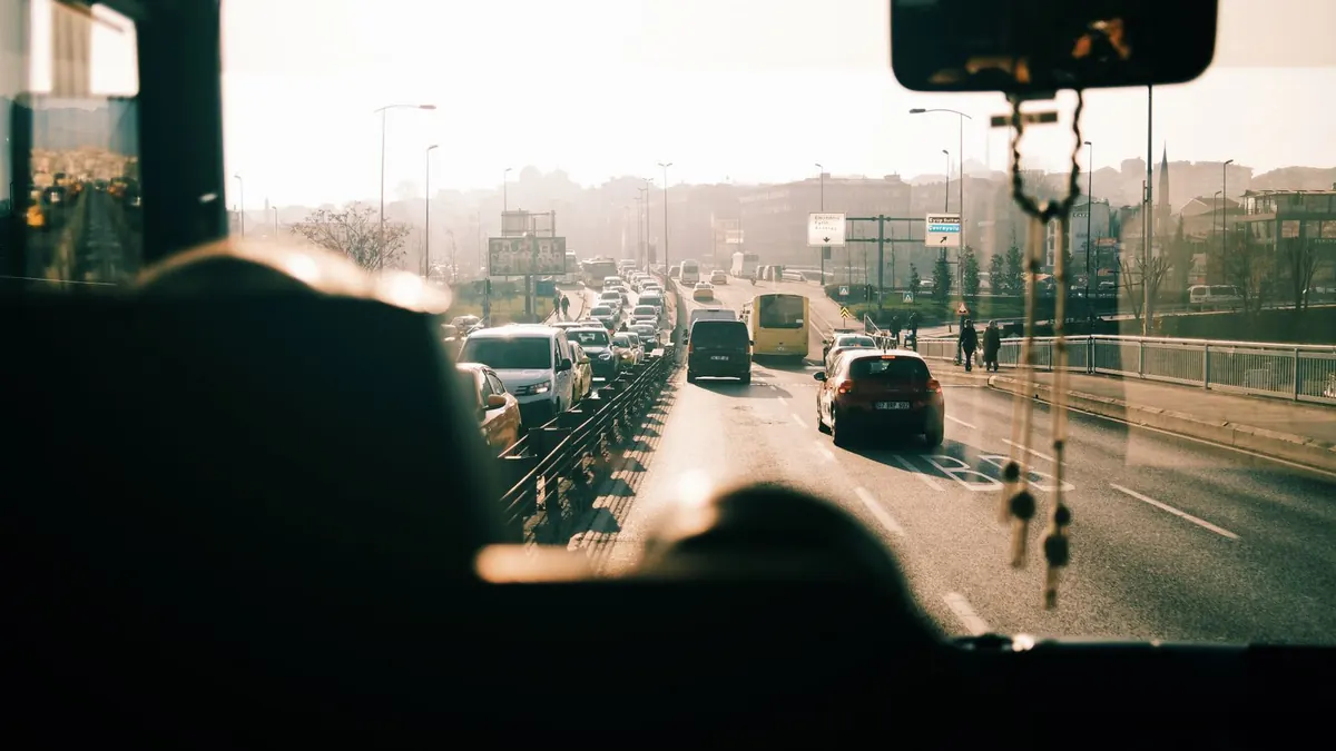 Blick aus dem Bus auf dichten Berufsverkehr bei tiefstehender Sonne