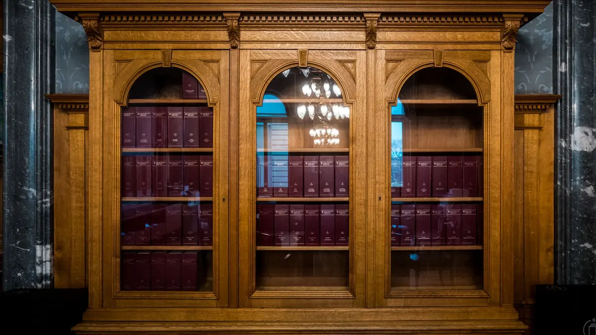 Hoher Holzschrank mit vielen Gesetzbüchern in einer klassischen Bibliothek