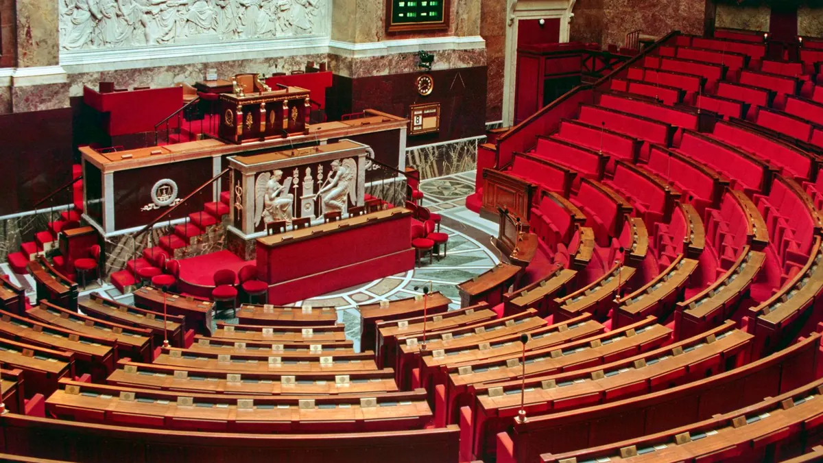 Leere rote Sitzreihen in einem großen Plenarsaal von oben