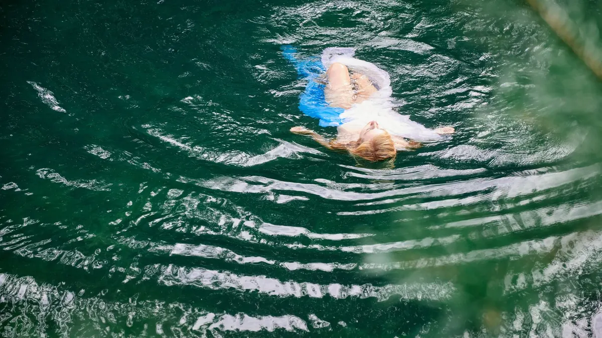 Schwimmerin gleitet durch das grüne Wasser eines Sees